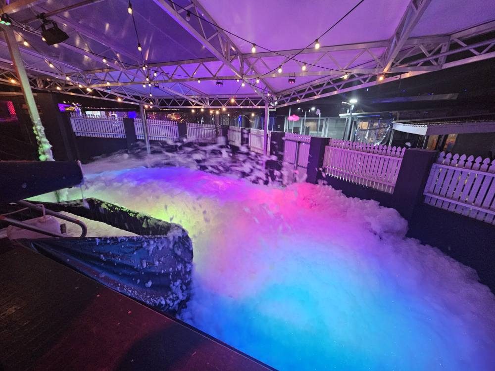 Colourful glow foam lit up at a night party